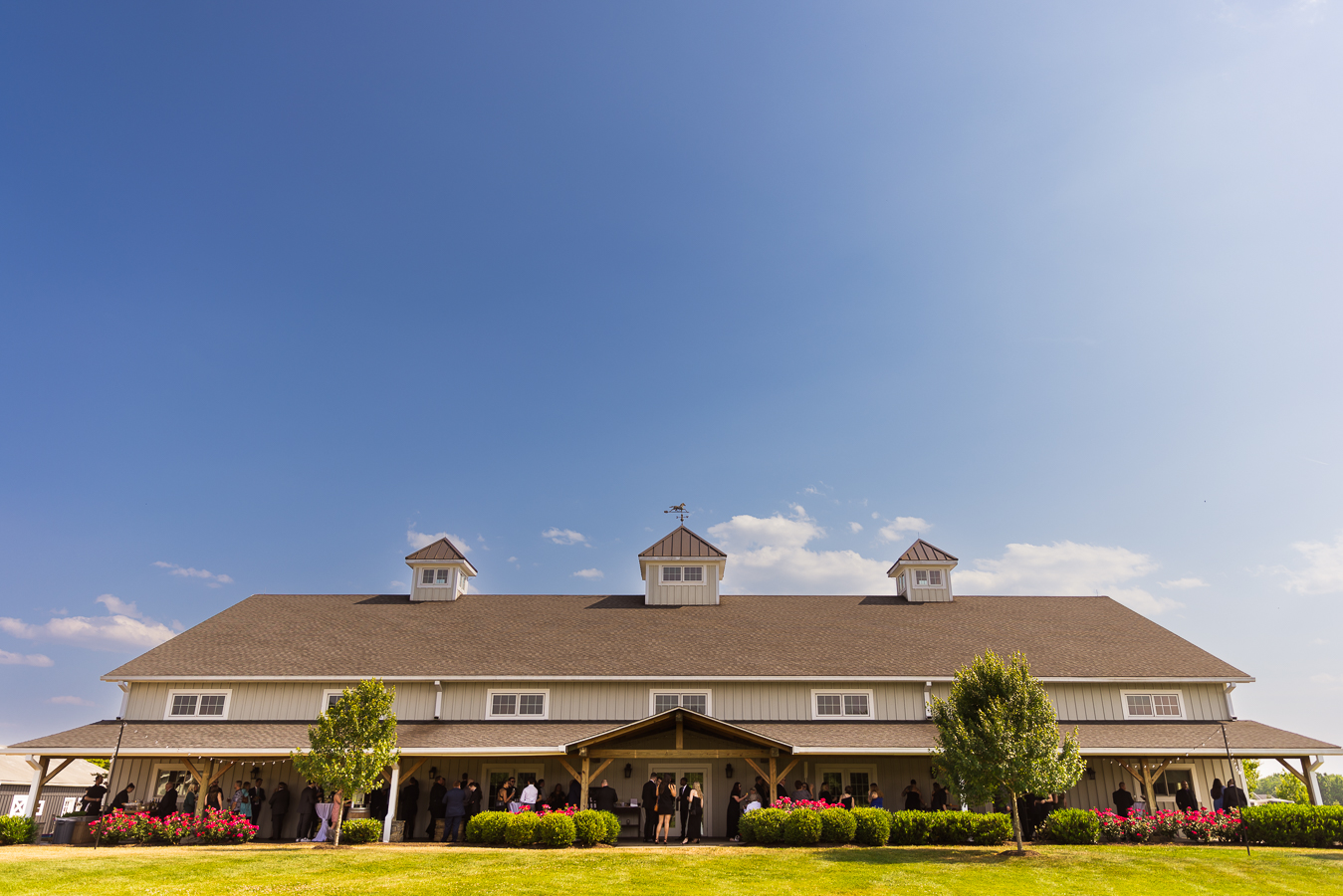 vibrant, colorful image of the outside of middleburg barn as everyone is mingling for cocktail hour 