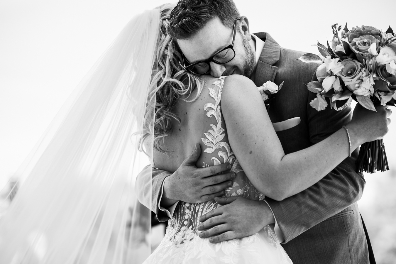 creative NJ Wedding Photographer, lisa rhinehart, captures this authentic black and white moment between the couple during their first look as they hug one another before their palace at somerset park wedding 