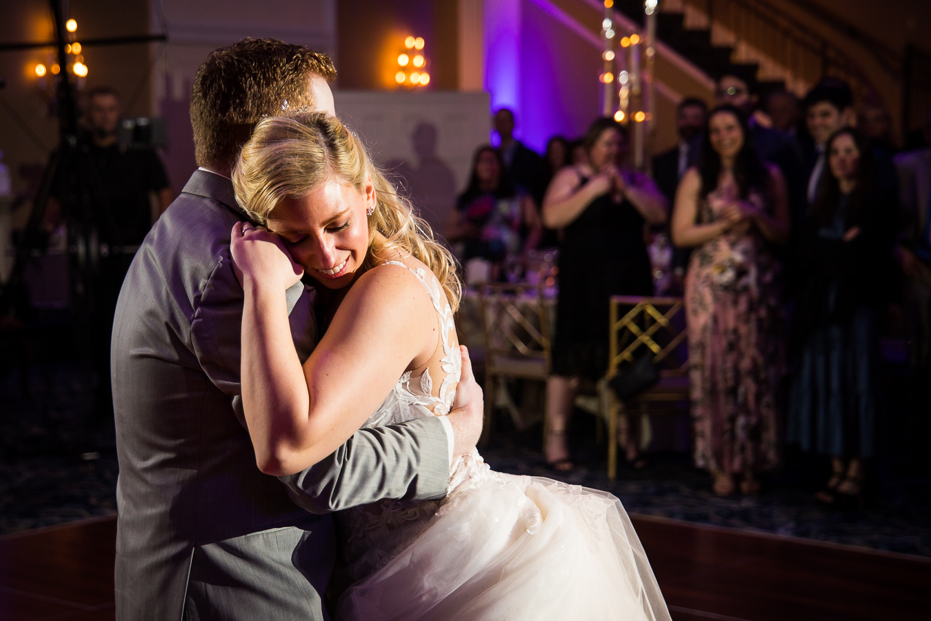 authentic wedding photographer, lisa rhinehart, captures this candid, authentic moment of the bride and groom holding each other close as they share their first dance together during their wedding reception at the palace at somerset park 