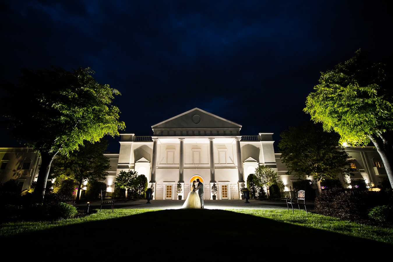 creative NJ Wedding Photographer, lisa rhinehart, captures this image of the bride and groom hugging one another for their end of the night shot as they stand in front of the palace for this unique image 