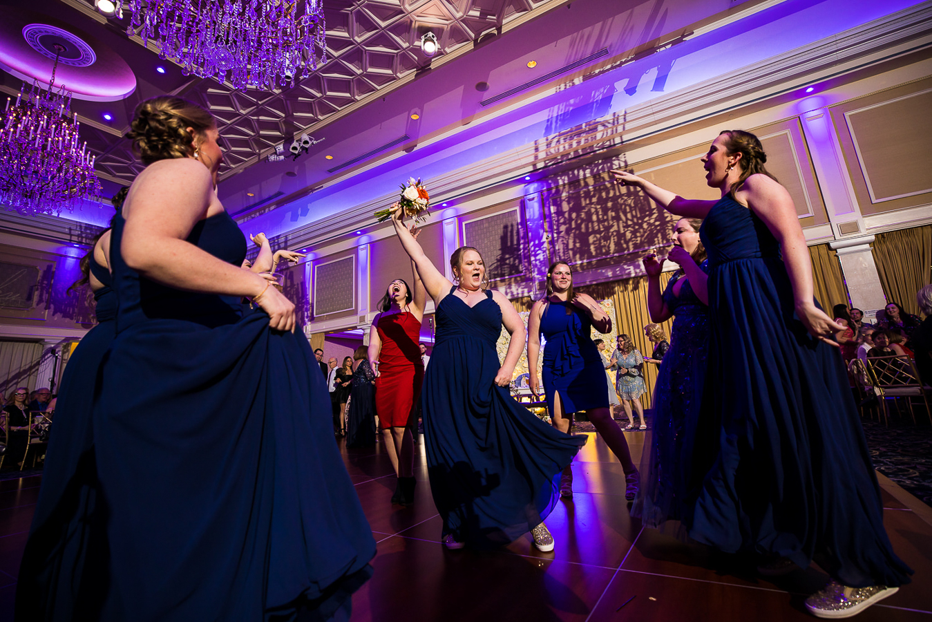 image of a bridemaid dancing around excited after she captures the bouquet during the wedding reception