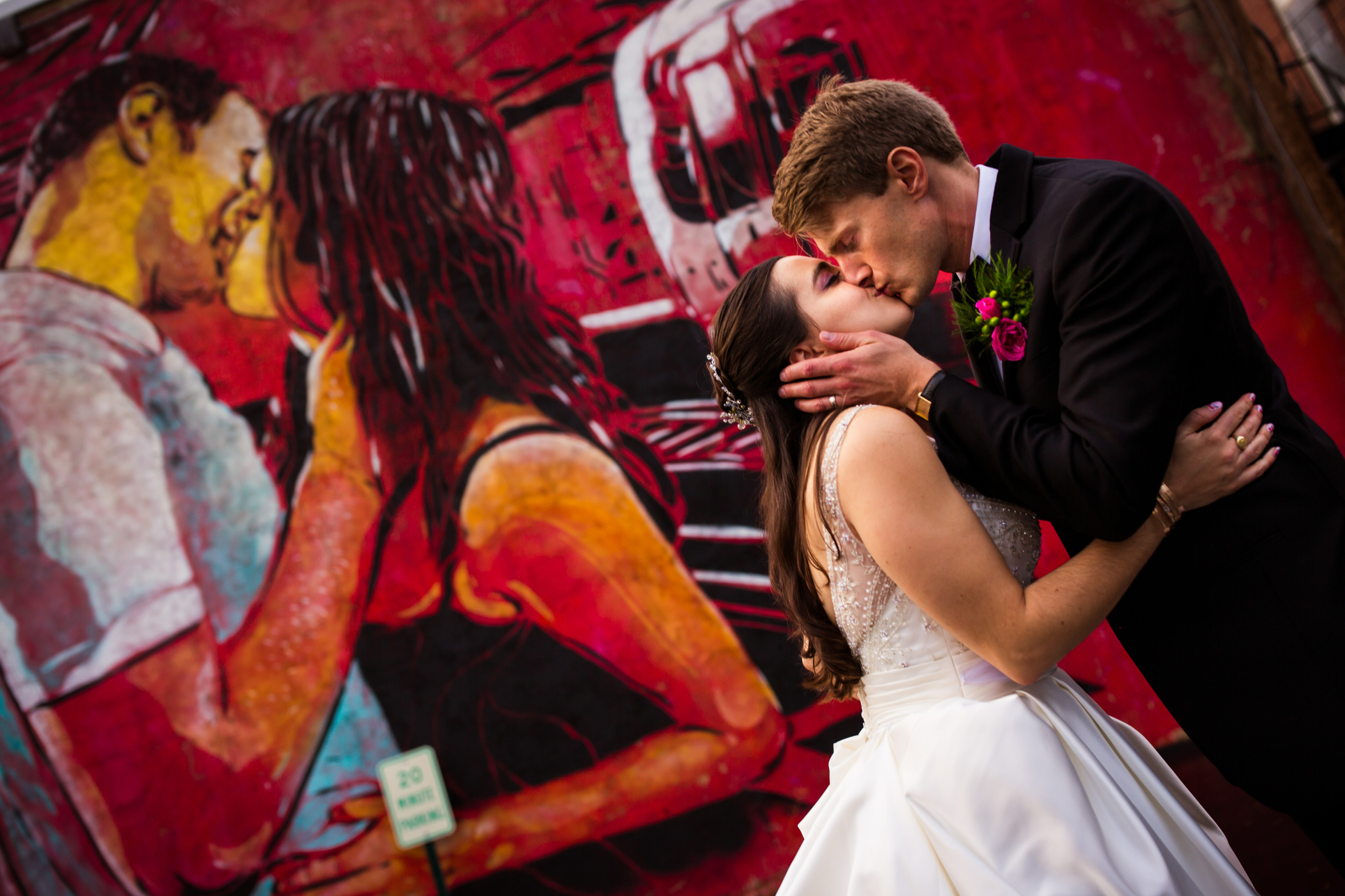 Creative York Wedding Photographer, Lisa Rhinehart, captures this unique, fun, creative image of the couple kissing one another as a couple kissing is painted on the wall behind them in this vibrant colorful mural
