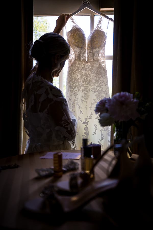rhinehart photography captures this unique perspective of the bride as she holds up her dress and admires it before her Country Club of York Wedding