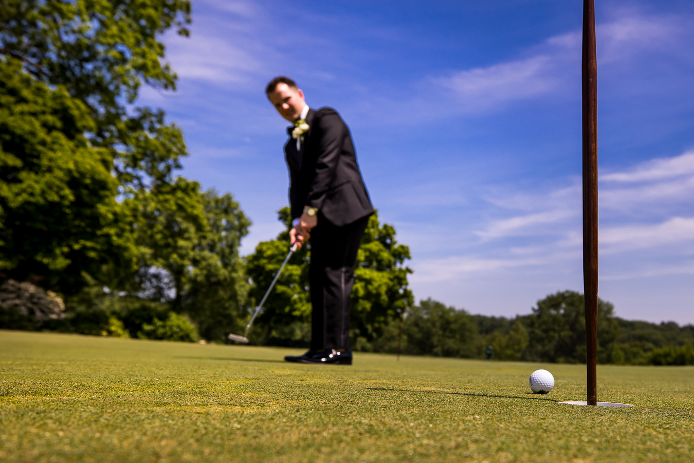 creative wedding photographer, rhinehart photography, captures this unique portrait of the groom golfing prior to the ceremony 