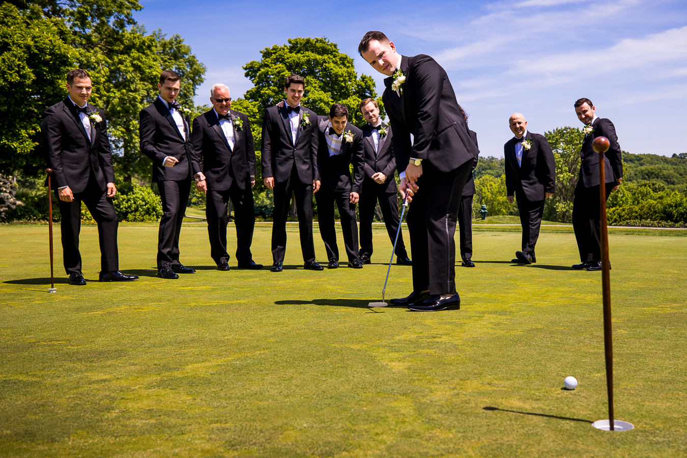 Country Club of York Wedding photographer, lisa rhinehart, captures this creative wedding party image of guys golfing together on the green before the ceremony 