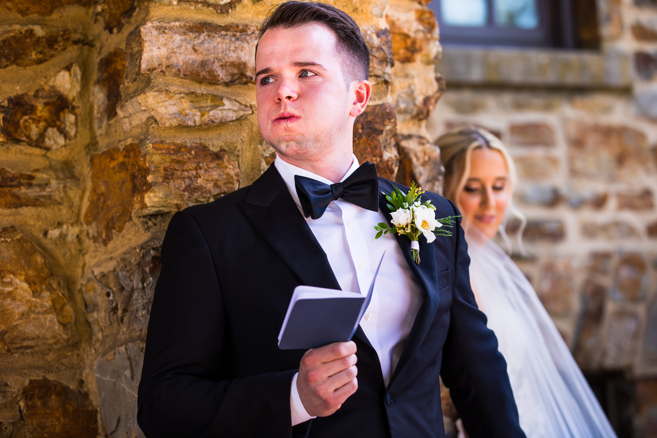 authentic wedding photographer, lisa rhinehart, captures this raw emotion from the groom as he holds his brides hand and reads their vows before their wedding ceremony 