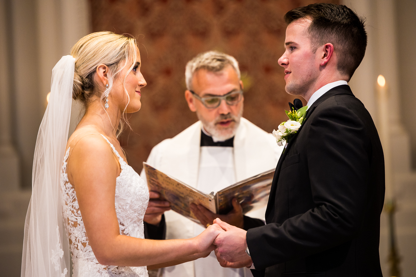 st pauls lutheran church wedding photographer, lisa rhinehart, captures this authentic, special moment between the bride and groom as they hold hands during their wedding ceremony inside of the church
