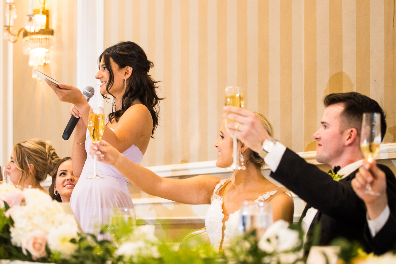 image of the bride and groom and a bridesmaid toasting at the wedding reception