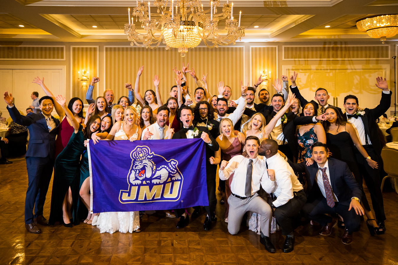 image of the bride and groom with all of their friends from james madision university on the dance floor together at this wedding reception in york pa