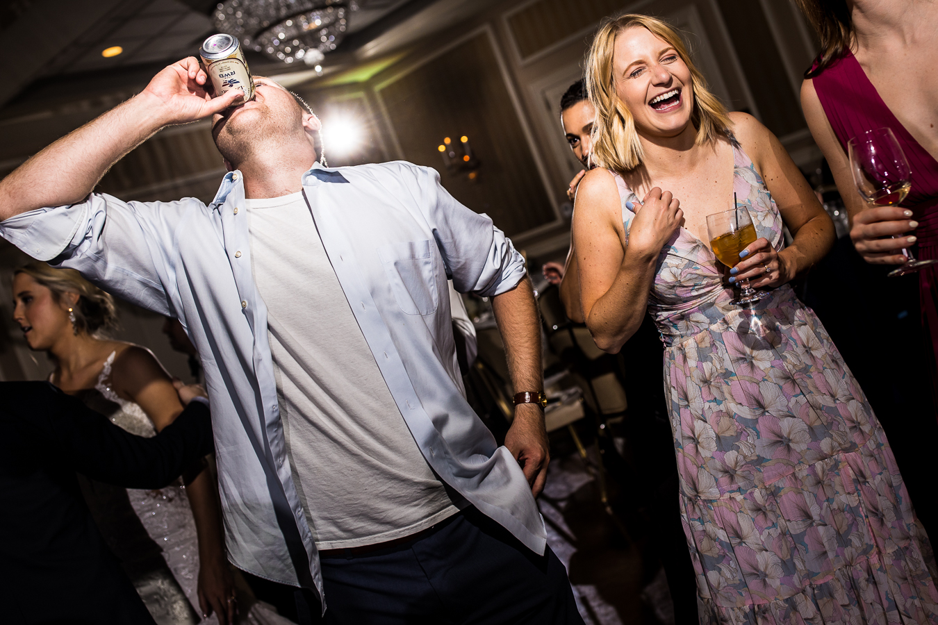 best pa wedding photographer, rhinehart photography, captures this image of a guest drinking his beer while another girl guest stands beside him laughing and smiling with a drink in her hand