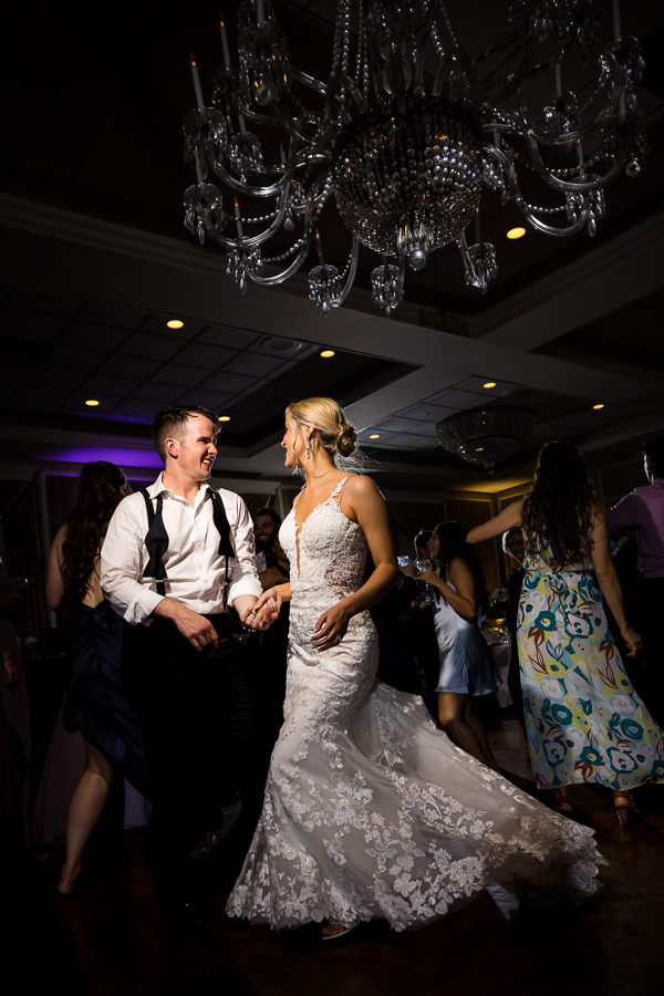 best pa wedding photographer, lisa rhinehart, captures this image of the bride and groom dancing together at this wedding reception in york pa with a giant glass chandelier above their heads