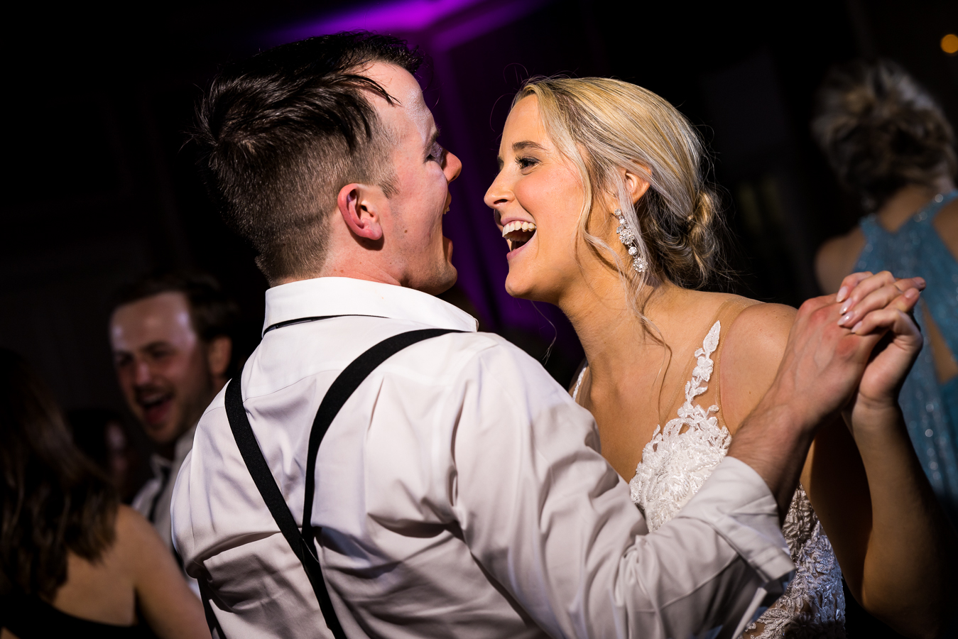 best pa wedding photographer, lisa rhinehart, captures this image of the bride and groom holding hands while singing and dancing with one another at their wedding reception 