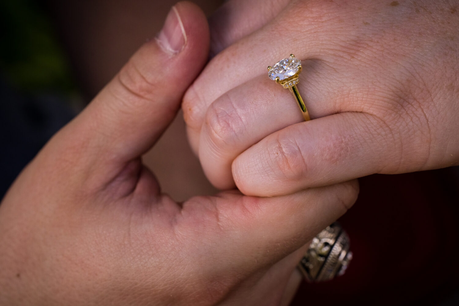 rhinehart photography, captures this close up image of the couple as they are holding hands and showing off the new ring 