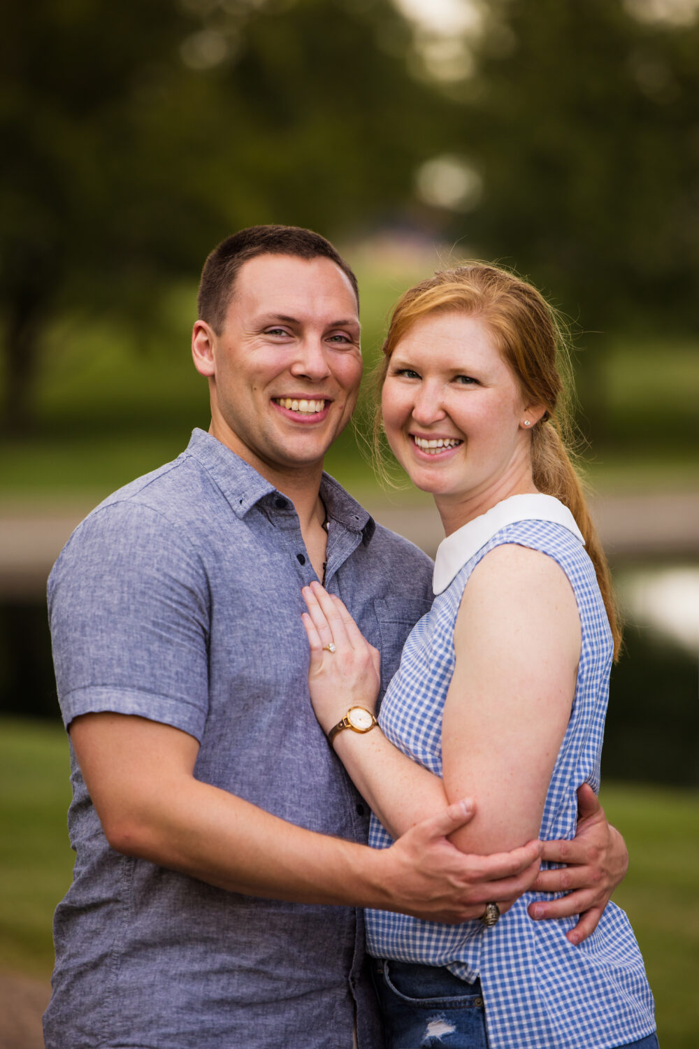 traditional image of the couple embracing one another and showing off the new ring and smiling from ear to ear captured by surprise proposal photographer, lisa rhinehart at the Missouri botanical gardens 