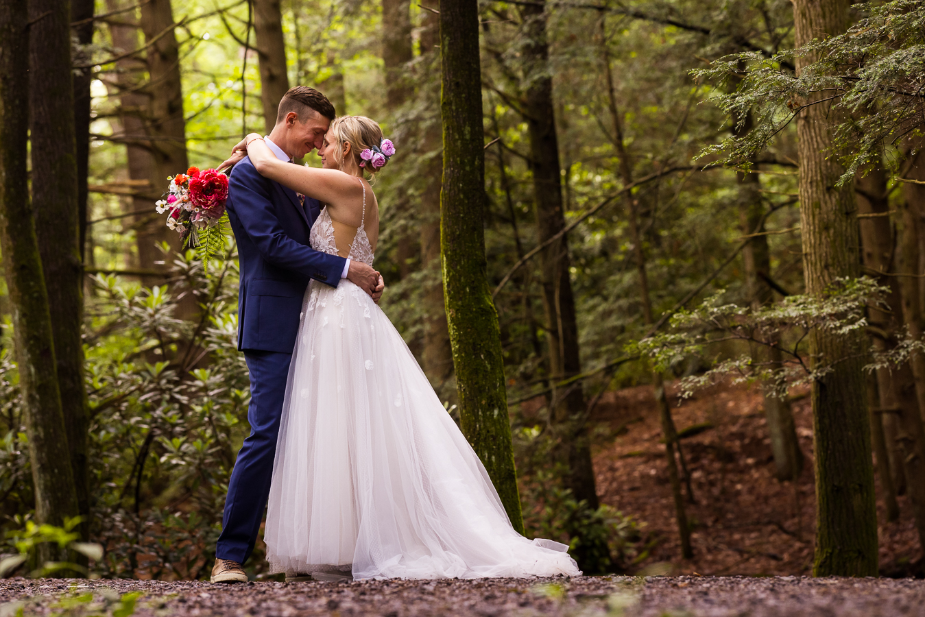 jim thorpe wedding photographer, lisa rhinehart, captures this traditional image of the bride and groom hugging one another as their heads touch during their romantic portraits before their micro wedding ceremony on a hiking trail 
