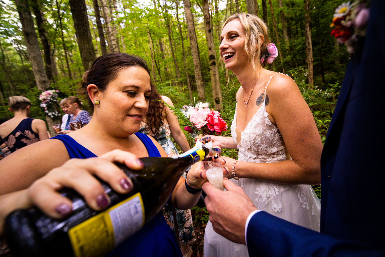 wedding photographer, lisa rhinehart, captures this image of friends pouring drinks for everyone after the wedding ceremony 