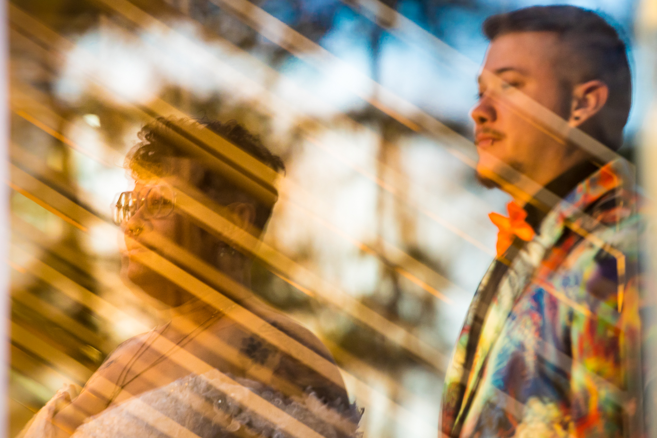 Creative LGBTQ Wedding Photographer, Lisa Rhinehart, captures this unique, creative image of the couple looking off into sunset caught in the reflection of the glass at the mansion 