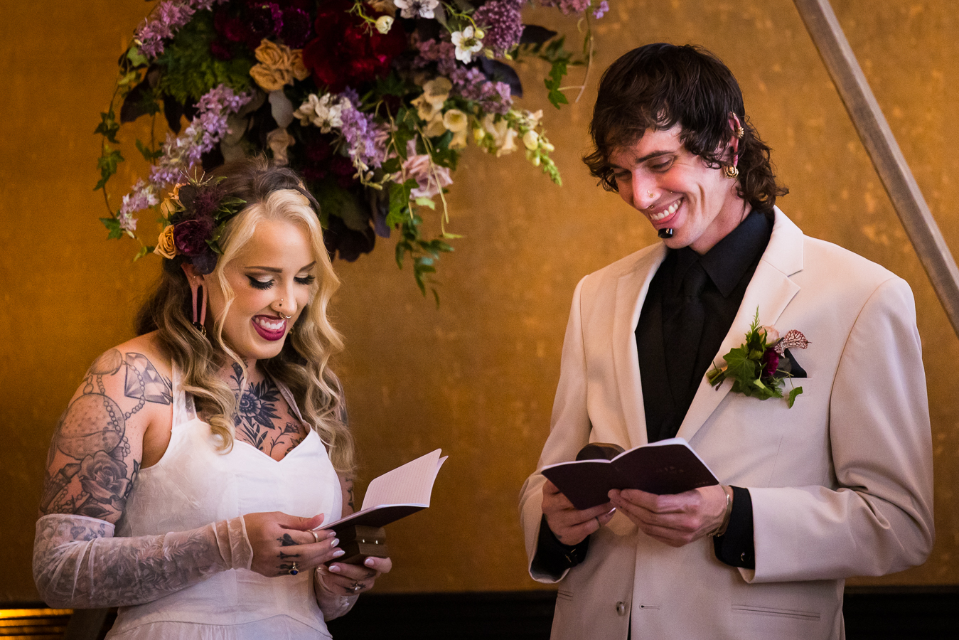 image of the bride and groom laughing and smiling with one another as they share their vows inside of the warehouse room at the hotel 