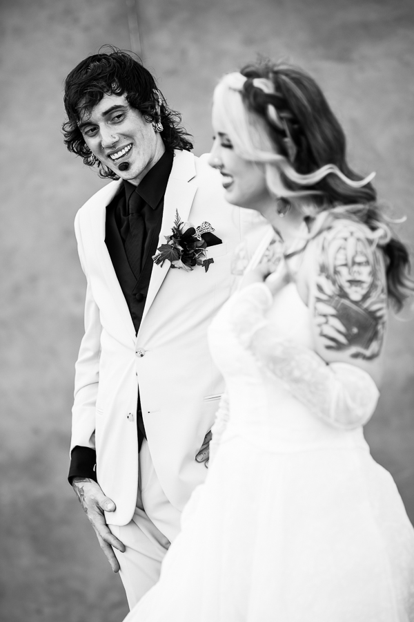 black and white image of the bride and groom walking together as the groom is in awe of his bride smiling at her as they walk outside of their wedding venue in lancaster