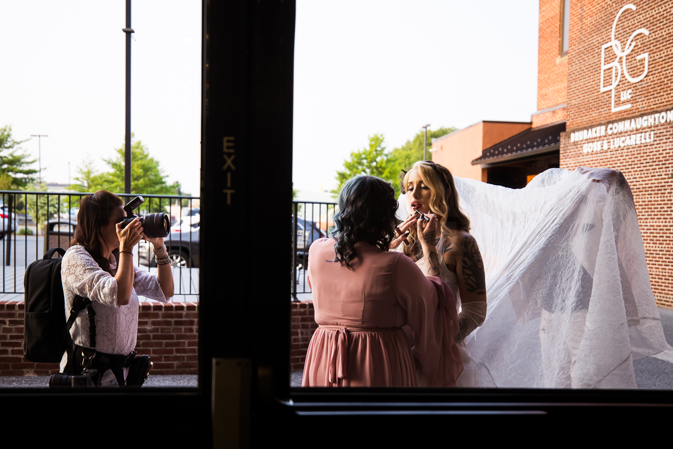 behind the scenes of lisa rhinehart capturing image of the bride getting her makeup touched up 