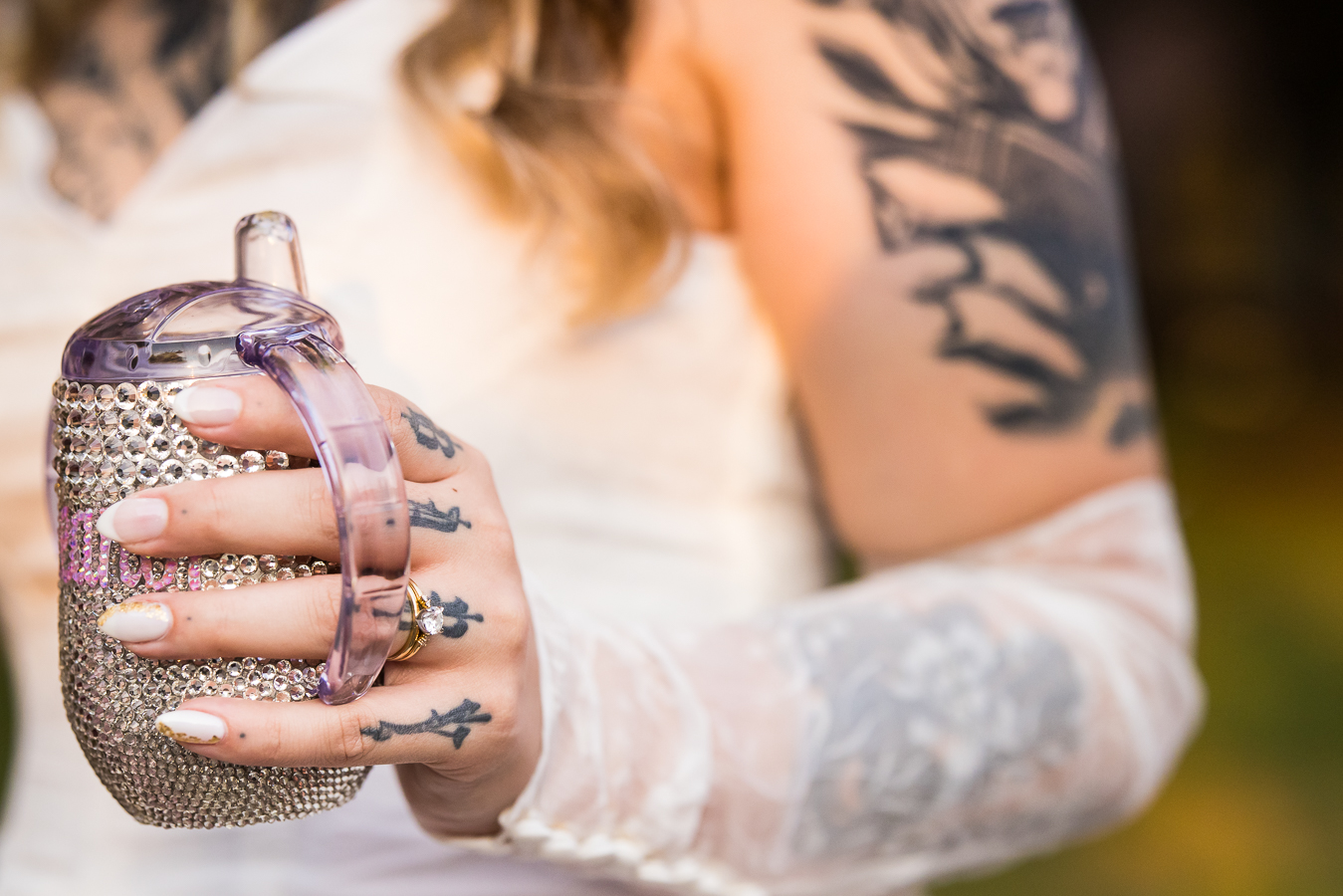 image of the bride holding her bedazzled sippy cup before heading into her wedding reception 