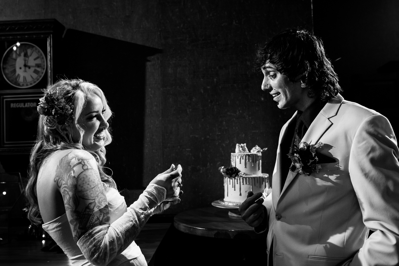 Cork Factory Hotel Wedding Photographer, lisa rhinehart, captures this black and white image of the couple laughing and smiling at eachother after cutting their wedding cake 