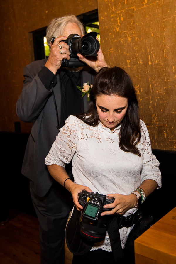 behind the scenes image of the brides dad grabbing some extra photos 