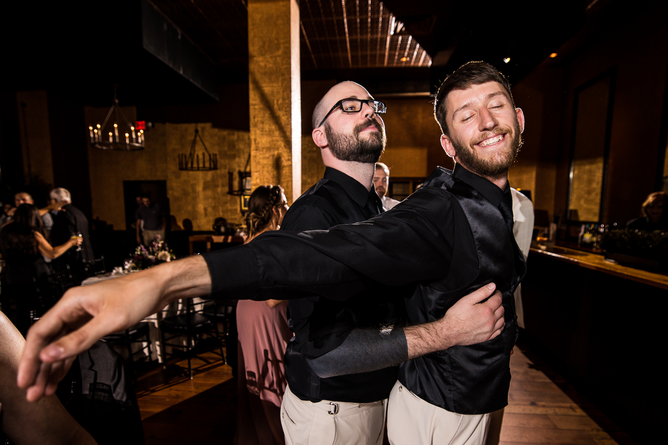 fun dancing image of two guys holding eachother in the titanic pose during the wedding reception