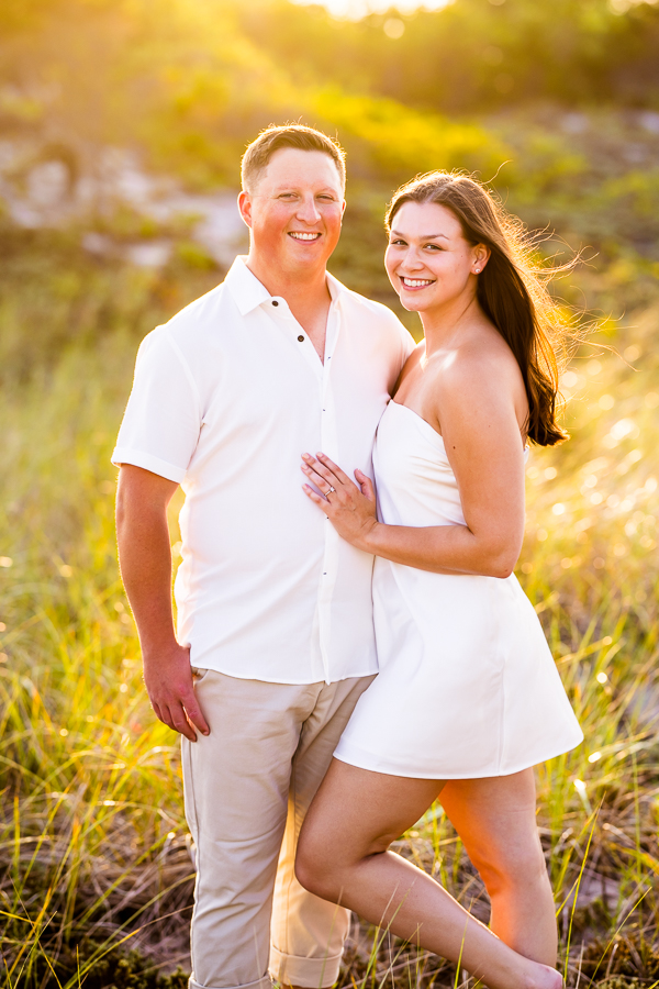 traditional portrait of this newly engaged couple as they pose together in the dunes and grass for their session