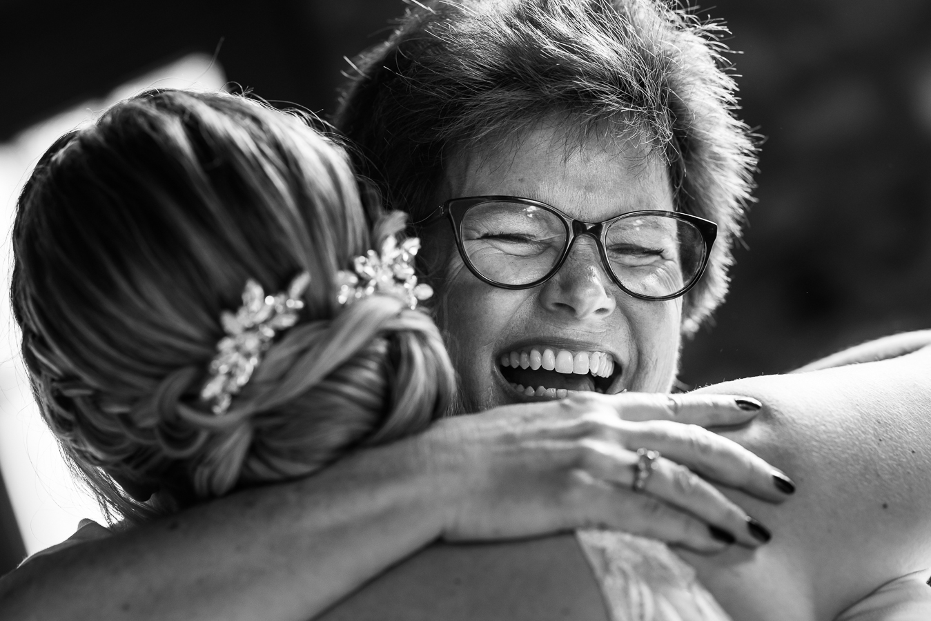 black and white image of the bride hugging family and smiling after the wedding ceremony in new hope, pa 