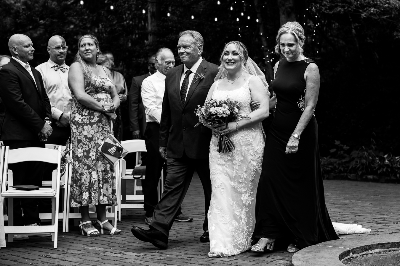 Holly Hedge Estate Wedding Photographer, lisa rhinehart, captures this image of the bride walking down the aisle with her mom and dad during their wedding ceremony 