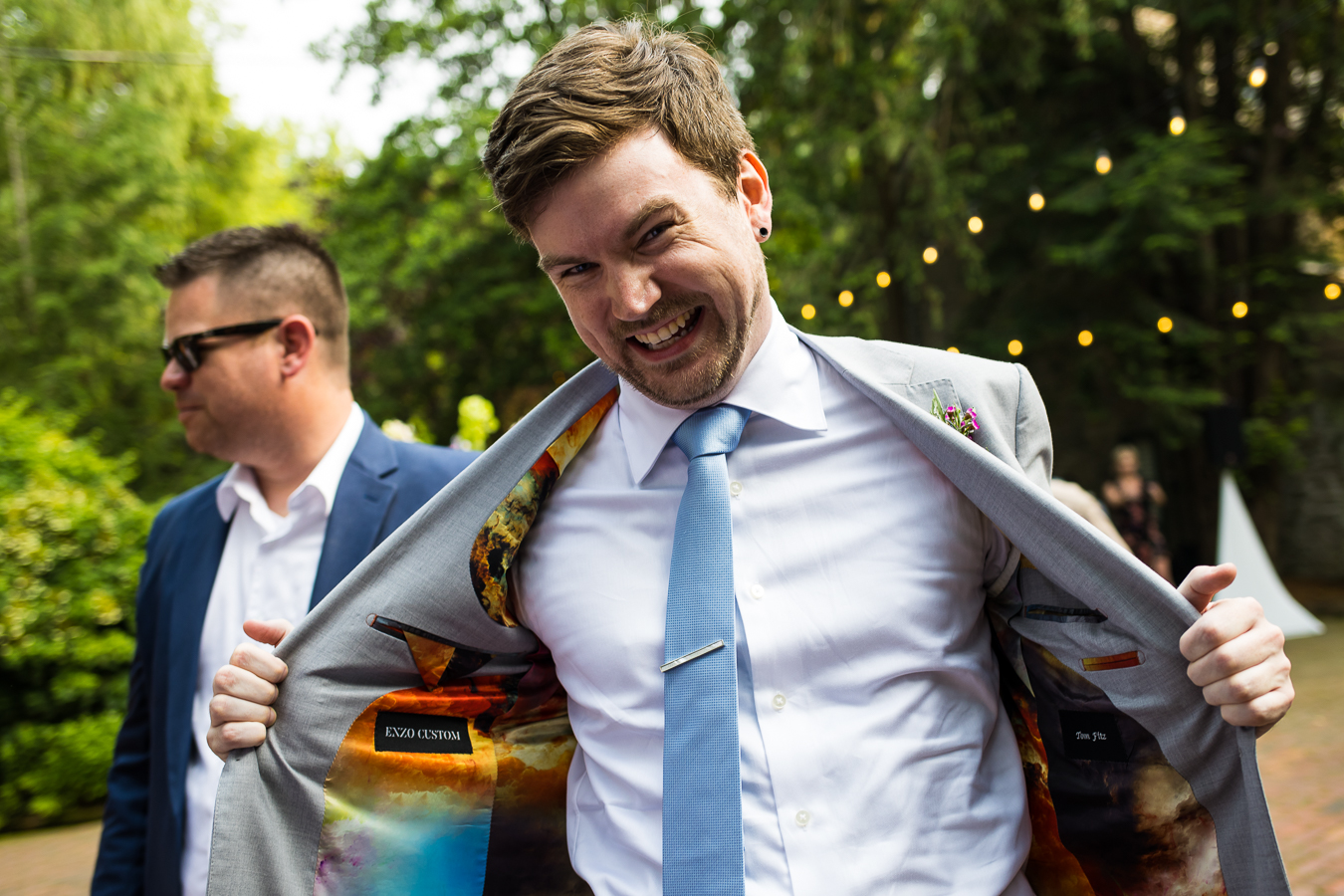 fun, colorful, vibrant image of the brother of the groom showing off his unique, colorful, custom suit for the wedding 