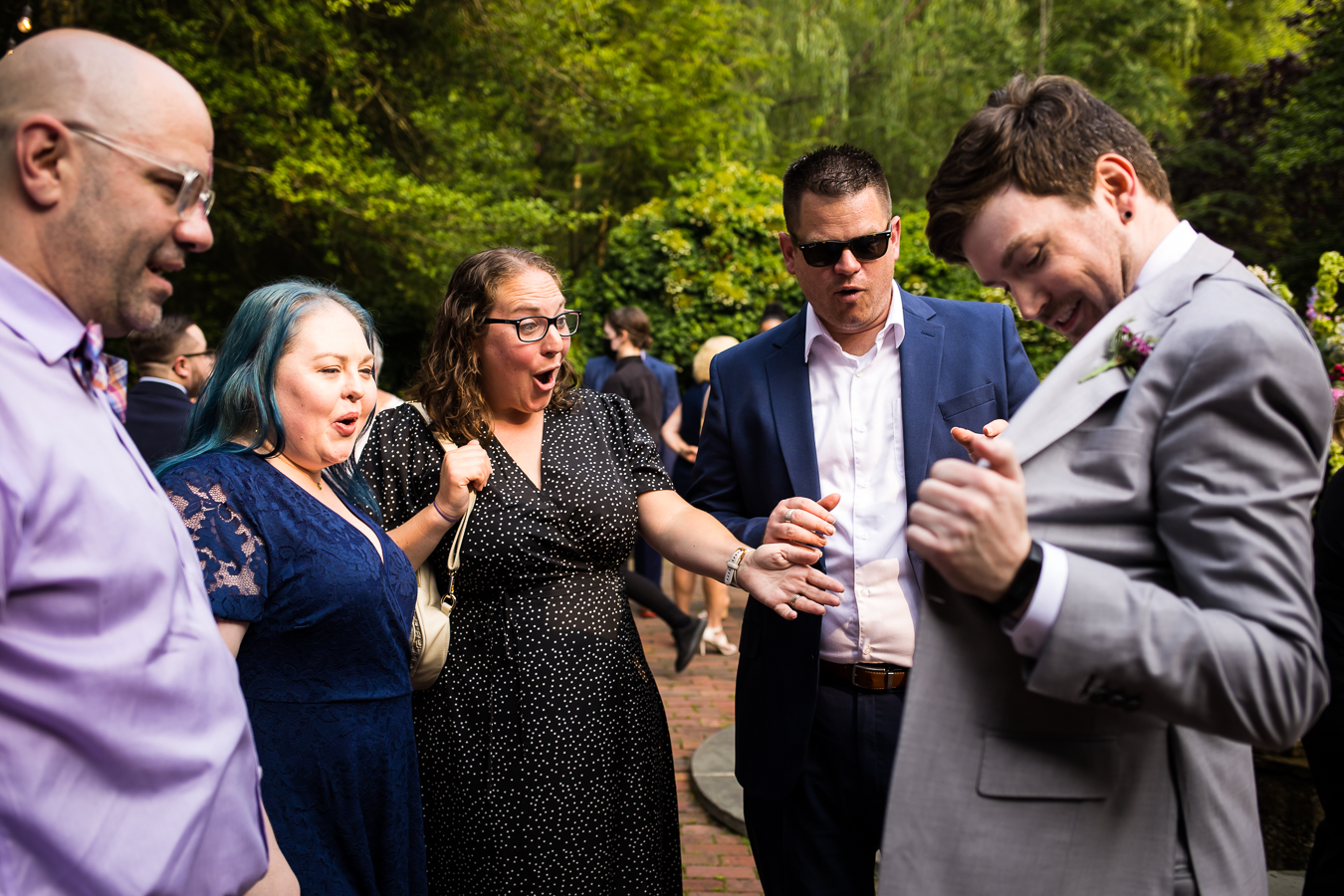 image of the brother of the groom showing off his custom suit to family and friends during cocktail hour in new hope , pa 