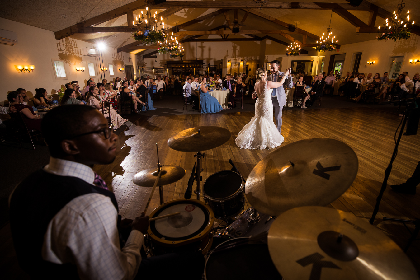 Holly Hedge Estate Wedding Photographer, lisa rhinehart, captures the couple as they share their first dance from a creative angle with the band in the image as well 