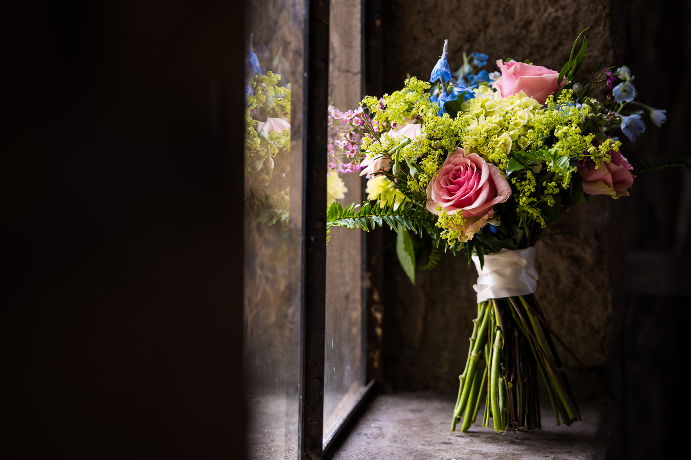 lisa rhinehart, best pa wedding photographer, captures this vibrant, colorful image of the brides bouquet as it sits against the window sill at their wedding venue 