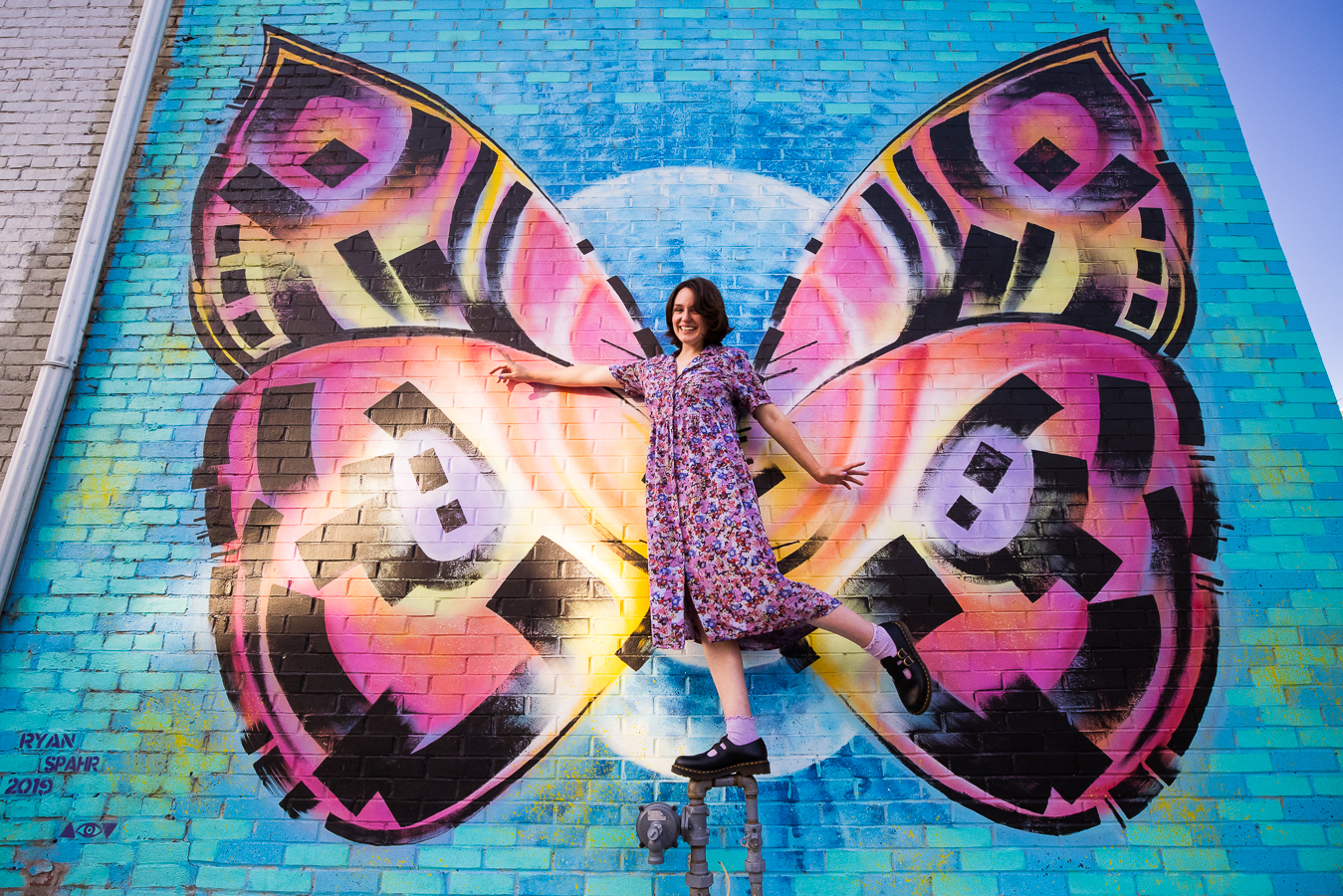 vibrant, colorful image of this senior as she stands in front of a colorful butterfly mural in downtown Harrisburg during this Creative Harrisburg Photography session