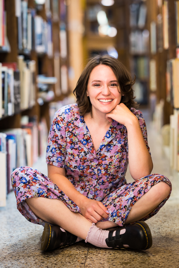 traditional portrait of this senior as she sits amongst the bookshelves during this Creative Harrisburg Photography session