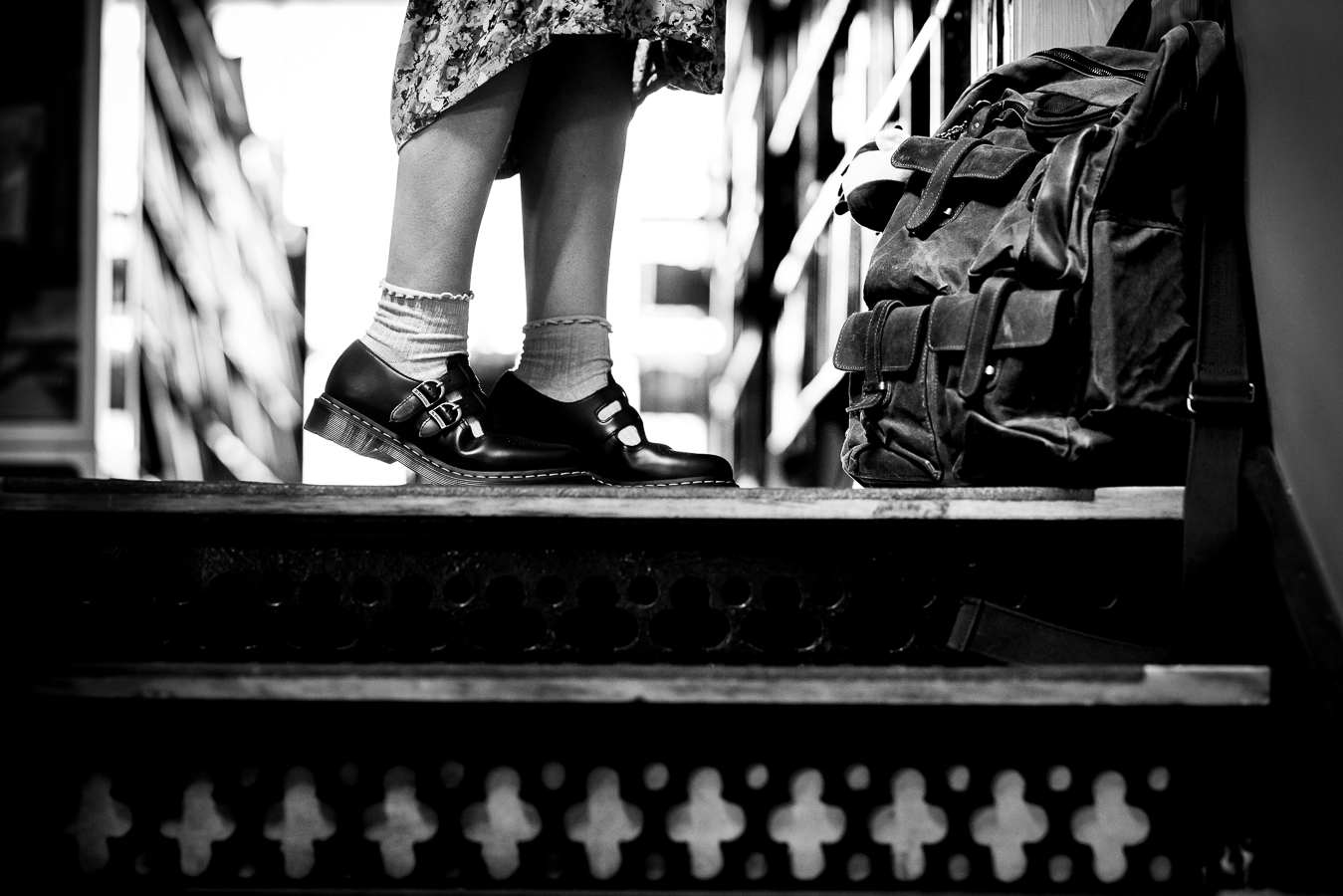 black and white image of this artists feet and her backpack during this senior portrait shoot