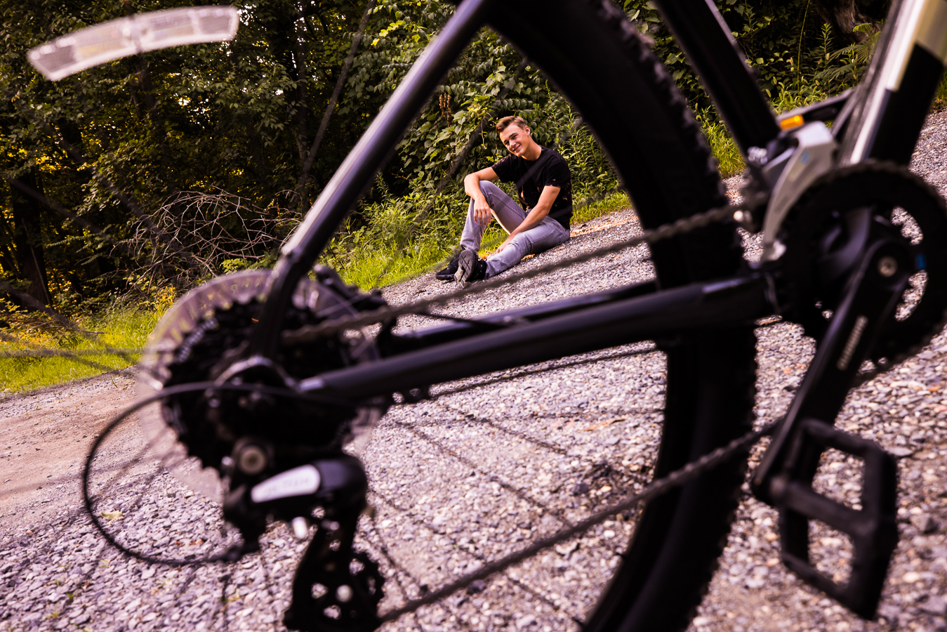 Creative Portrait Photographer, lisa rhinehart, captures this unique creative perspective of this senior through the wheel of his bike during this outdoor session in shippensburg pa 