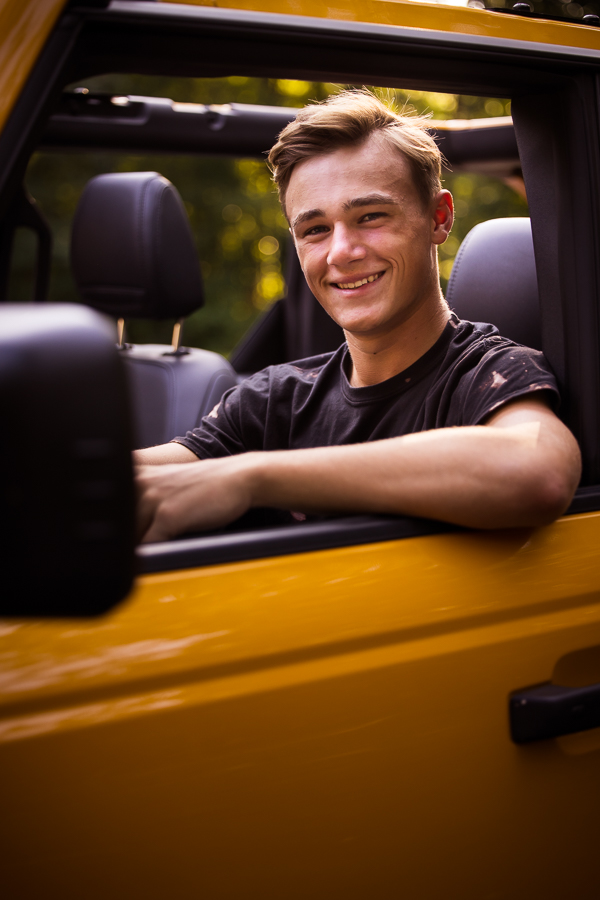 lisa rhinehart, shippensburg photographer, captures this traditional image of this senior as he drives off in his yellow vehicle during his session 
