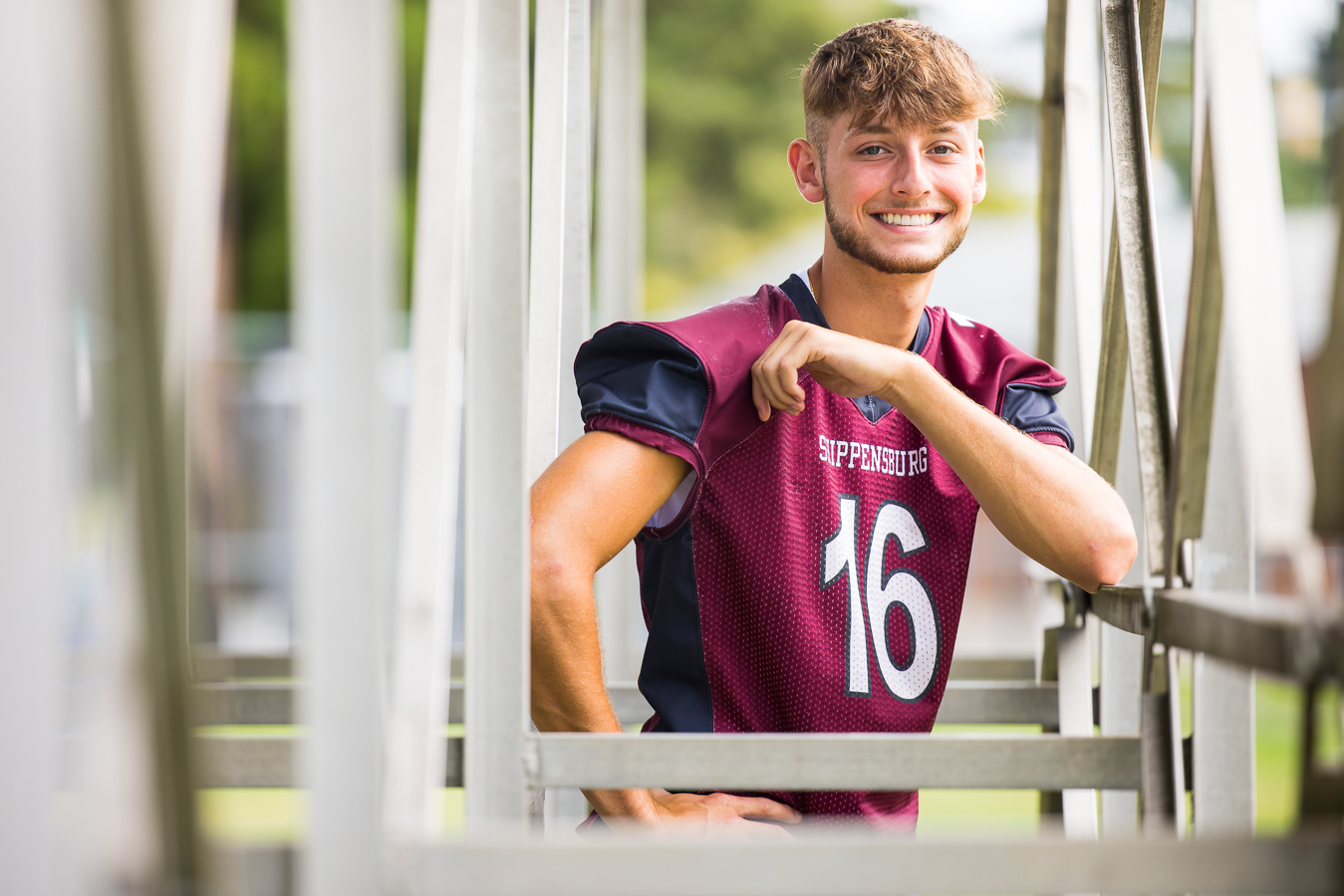 unique, vibrant image of this senior as he stands underneath the bleachers of his football stadium during his senior portrait session in shippensburg pa 