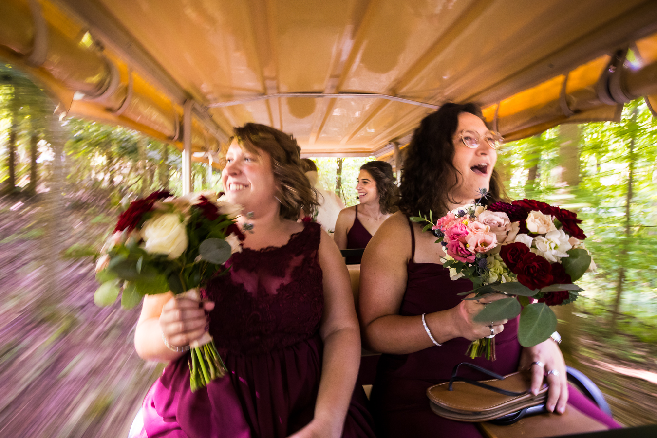 creative outdoor wedding photographer, lisa rhinehart, captures this unique, creative image of the bridesmaids as they ride in the golf cart to the wedding ceremony as the trees blur behind them