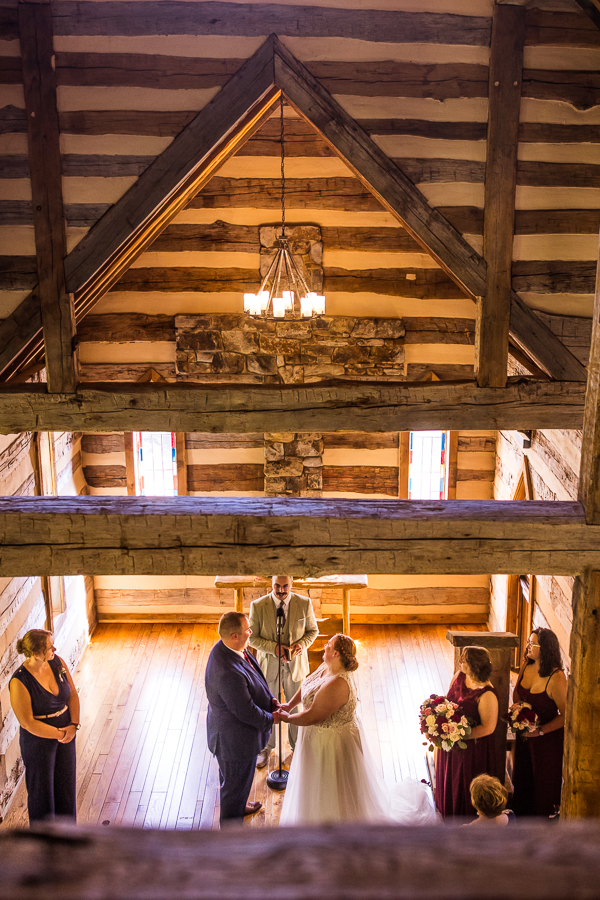 creative, unique perspective from the wedding ceremony of the bride and groom as they hold hands captured from above in a loft by creative Oak Lodge Wedding Photographer, rhinehart photography