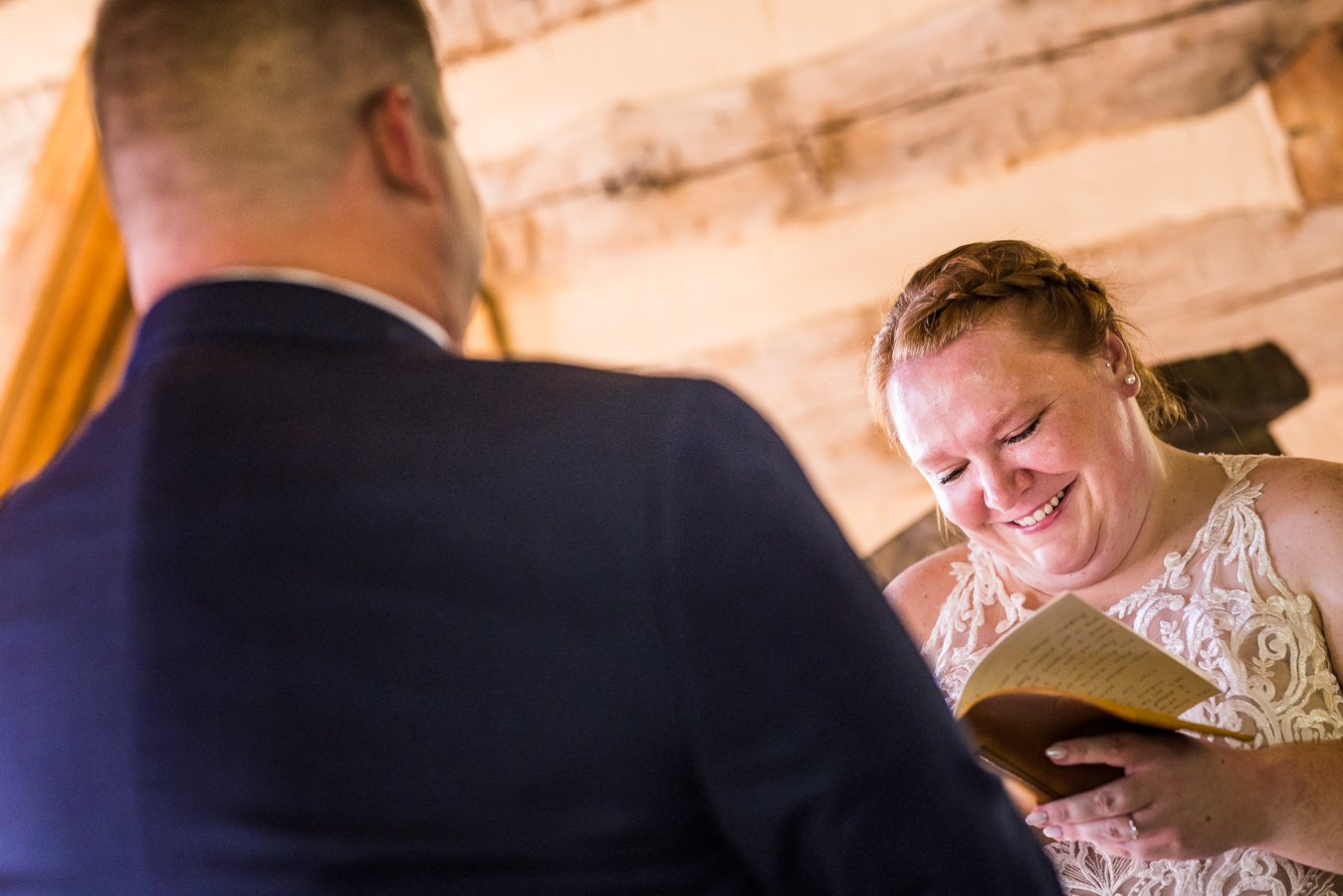 emotional moment between the bride and groom as they share their vows with one another during their wedding ceremony inside of the intimate xozy log chapel in stahlstown, pa 