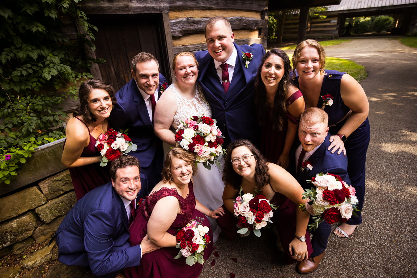 fun, vibrant, colorful image of the bride and groom surrounded by their wedding party after their ceremony inside of the cozy chapel at oak lodge in stahlstown pa 