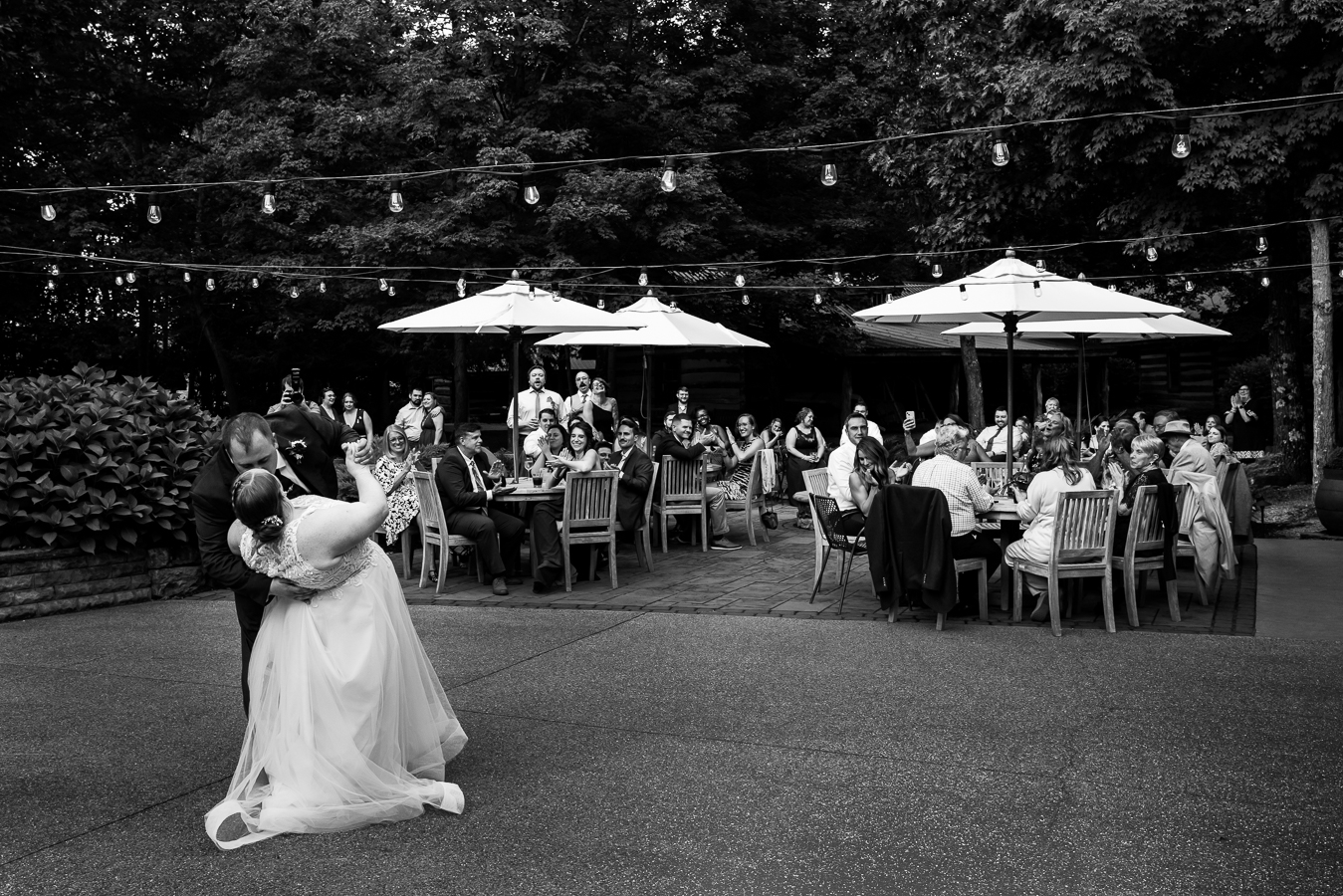 Oak Lodge Wedding Photographer, rhinehart photography, captures this photojournalistic moment of the bride and groom dancing together while their guests sit at the outdoor tables watching them dance while clapping and smiling during this outdoor wedding reception in stahsltown, pa 