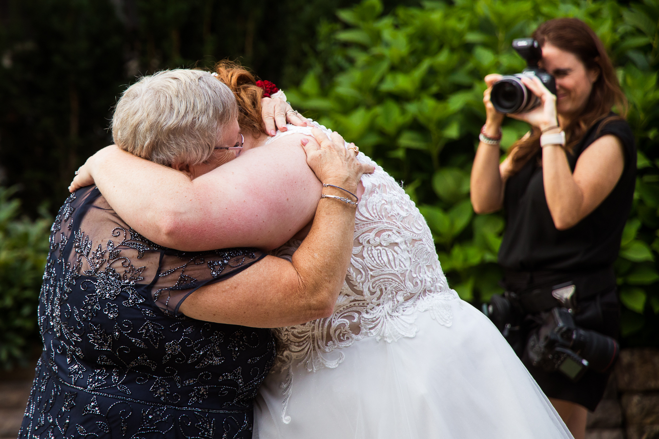 another perspective of the bride and her mom sharing their mother daughter dance together as they hug each other during this emotional moment of the wedding reception 
