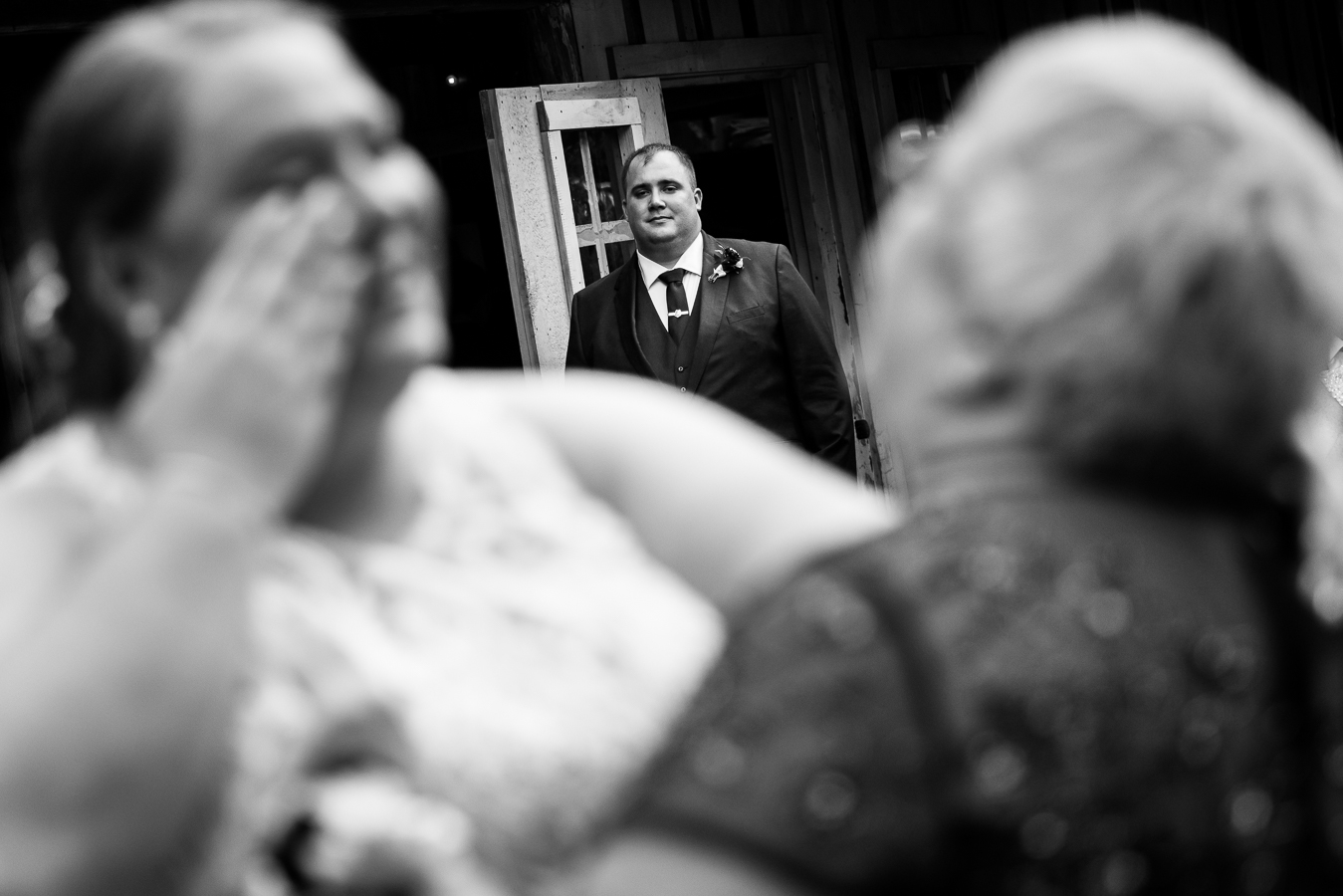 Oak Lodge Wedding Photographer, rhinehart photography, captures this black and white image from a unique perspective of the groom lovingly watching his new bride wipe away her tears as she shares her mother daughter dance 