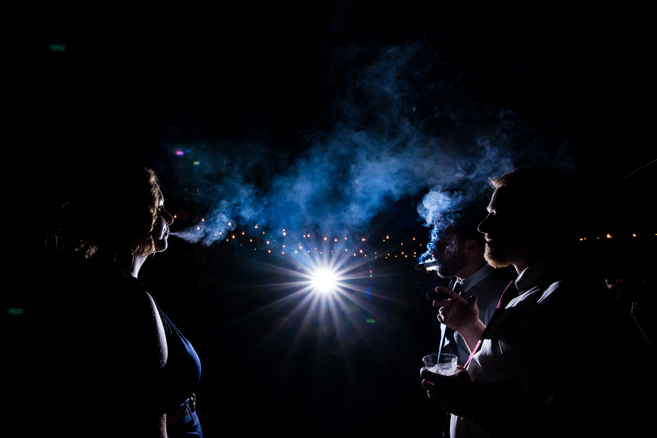 creative, fun image of guests as they smoke together and the smoke captured in the light of the night in stahlstown pa 
