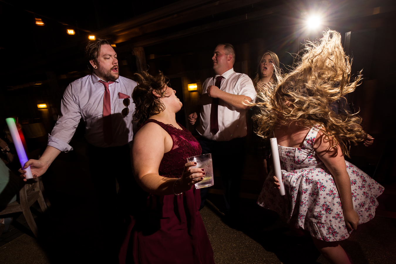 creative, fun Oak Lodge wedding reception photographer, rhinehart photography, captures this unique, fun image of guests as they dance together and their hair is flying through the air as they dance with their colorful giant glowsticks